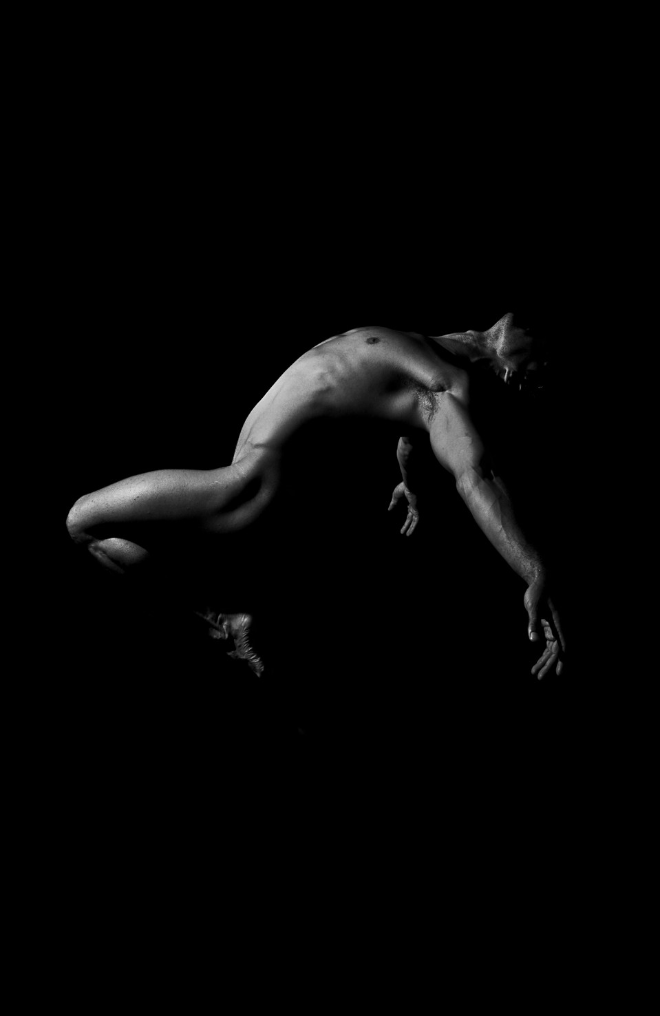 Figura desnuda encorvada hacia delante en pleno movimiento, casi en horizontal, sobre fondo negro.