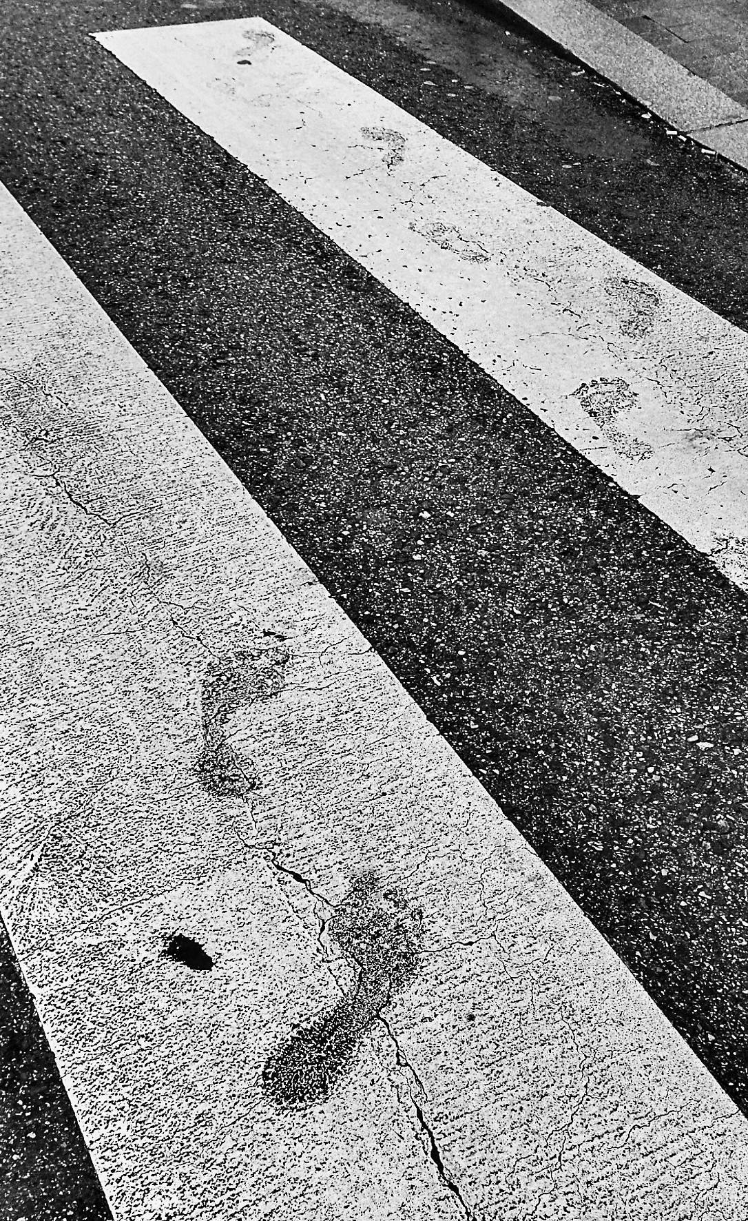 Barefoot footprints across a zebra crossing.