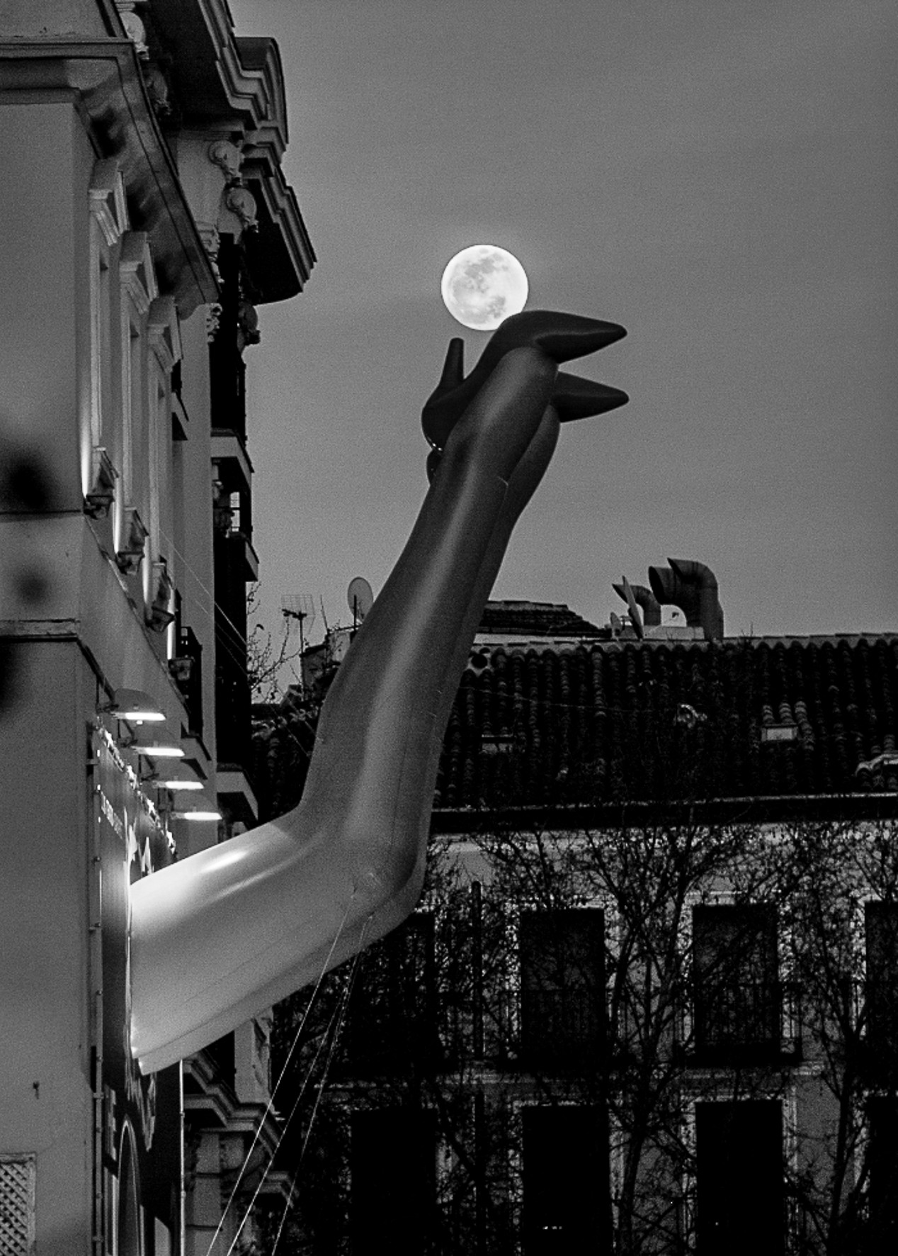A woman's leg in a high heel emerging from a window against a bluish sky, with a moon above.