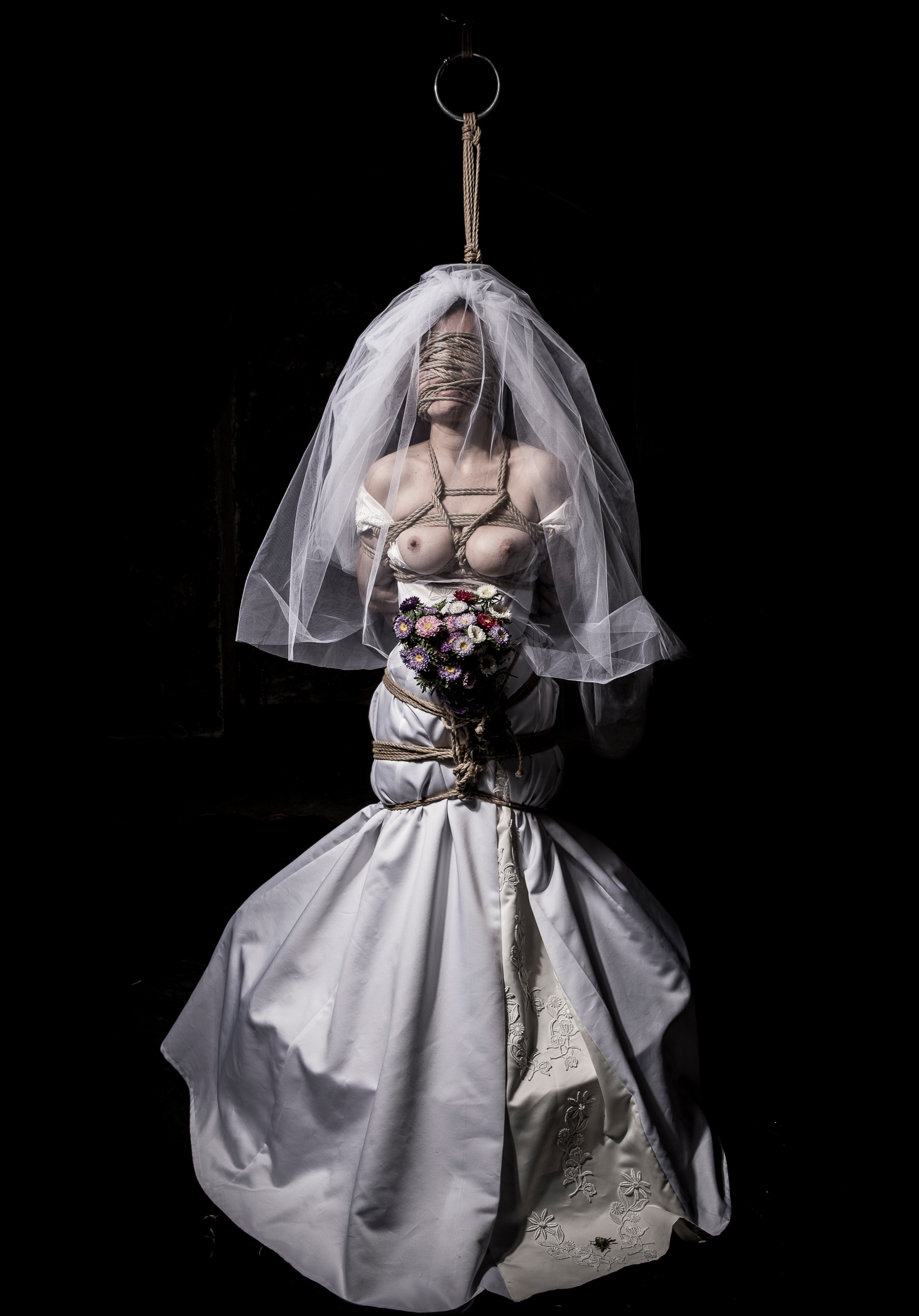 "El contrato". A mannequin in a wedding dress and veil, suspended in the void.