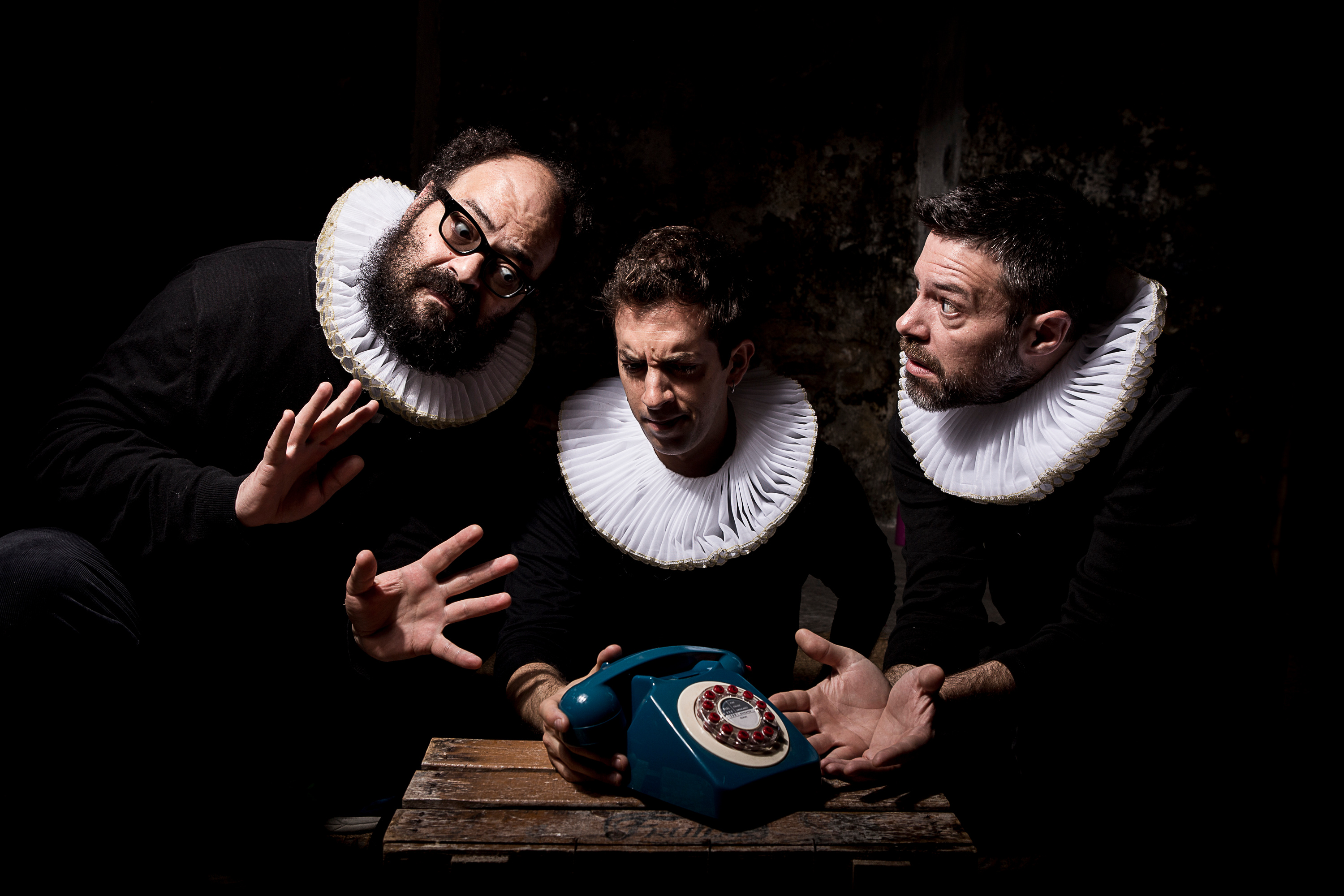 "La vida moderna". Three men in ruff collars around an old telephone.